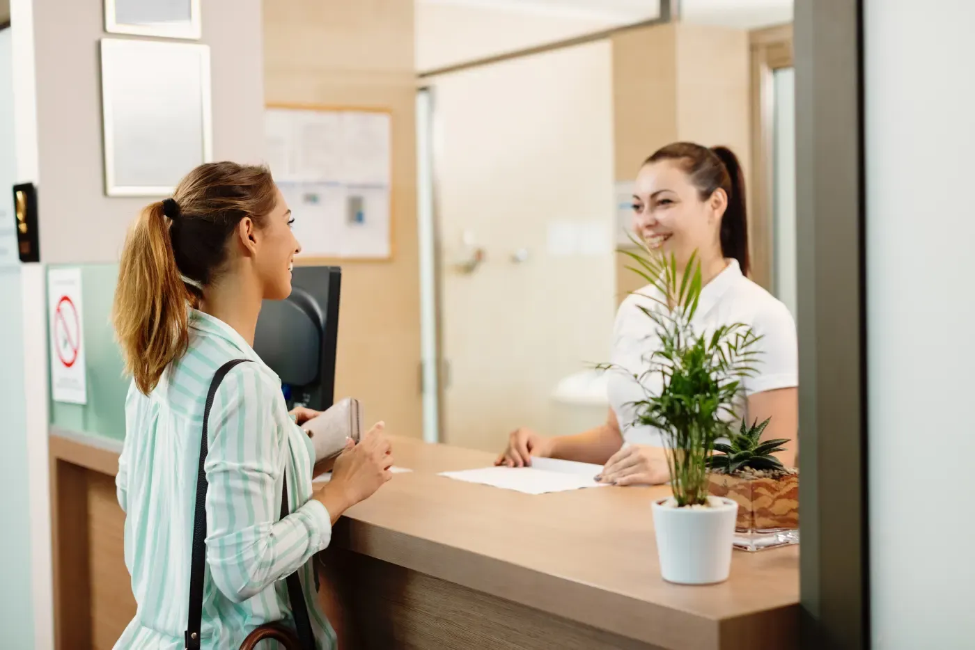 Client checking in with a receptionist at a spa front desk